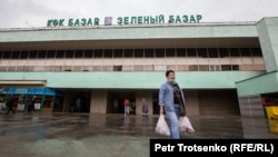 Көк базардан зат алып шығып келе жатқан әйел. Алматы, 18 наурыз 2020 жыл.