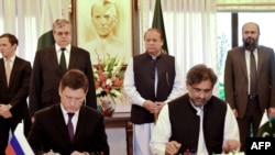 Russian Energy Minister Aleksandr Novak (L) and Pakistani Petroleum Minister Shahid Khaqan Abbasi sign an agreement of the North-South gas pipeline project as Pakistani Prime Minister Nawaz Sharif looks on during a ceremony in Islamabad on October 16.