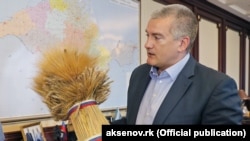 Фермери окупованого Криму переживають кризу через неможливість вивезти зерно чи продати за адекватною ціною. На фото: російський очільник Криму Аксьонов зі снопом пшениці