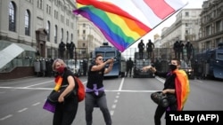 LGBT activists wave a rainbow and an old Belarusian flag during an anti-government rally in Minsk in September 2020.