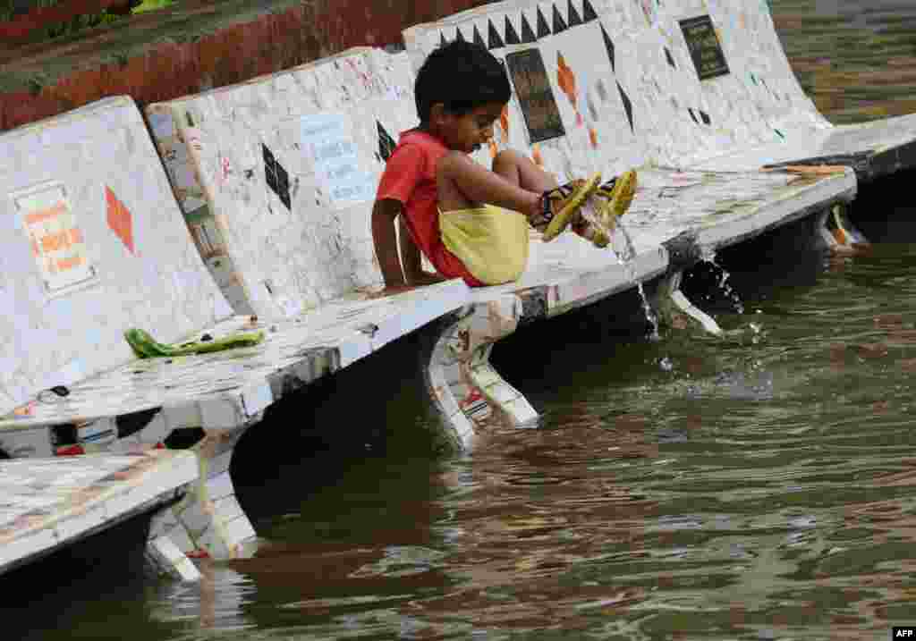 A child reacts to floodwaters in Ahmedabad after heavy rains lashed Gujarat state. (AFP/Sam Panthaky)