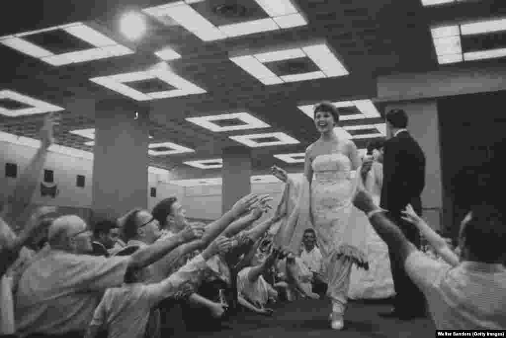 A Soviet model on the catwalk before a grabby crowd. A New York Times reporter who visited the exhibition acknowledged the achievements of the Soviet space industry on display but decried what he saw as a misrepresentation of daily Soviet life.