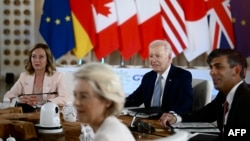 U.S. President Joe Biden (center), Italian Prime Minister Giorgia Meloni (left), and British Prime Minister Rishi Sunak attend a working session during the G7 summit hosted by Italy.