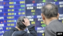 Pedestrians look at share prices on a board in Tokyo. Japan in the 1990s is an example of how "fiscal and monetary aspirin can kill the patient if used to treat a serious disease."