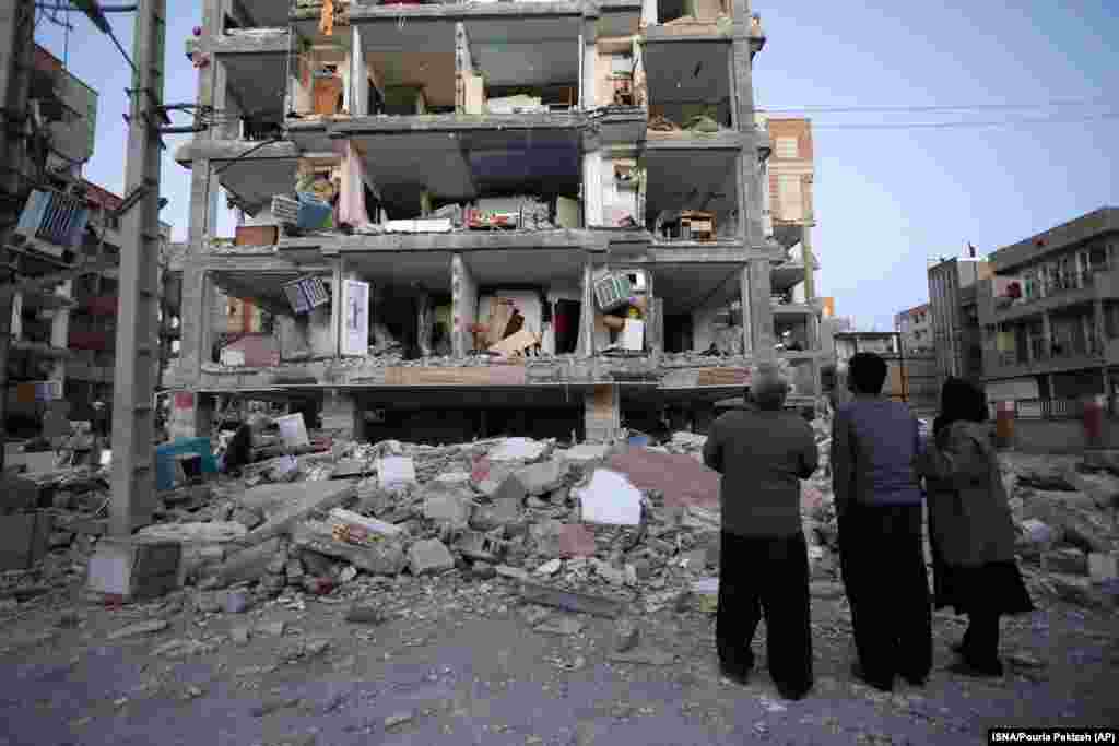 People look at destroyed buildings after an earthquake at the city of Sarpol-e-Zahab in western Iran, on Monday.