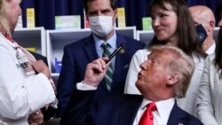 Donald Tramp pokazuje olovku koju je dobio na poklon i kojom je potpisao uredbe o smanjenju cena lekova, Vašington, 24. jul