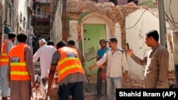 Pakistani volunteers collect debris from a demolished Ahmadi mosque in the eastern city of Sialkot on May 24.