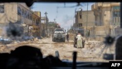 تصویری از داخل یک خودروی زرهی ارتش عراق باقی‌مانده‌هایی از شهر قدیم موصل را نشان می‌دهد