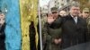 Ukrainian President Petro Poroshenko pays his respect to a Ukrainian flag found close to the remains of fallen soldiers in eastern Ukraine. Local elections this week are being seen as an important barometer of how Ukrainians think his administration is handling the country's myriad problems. 