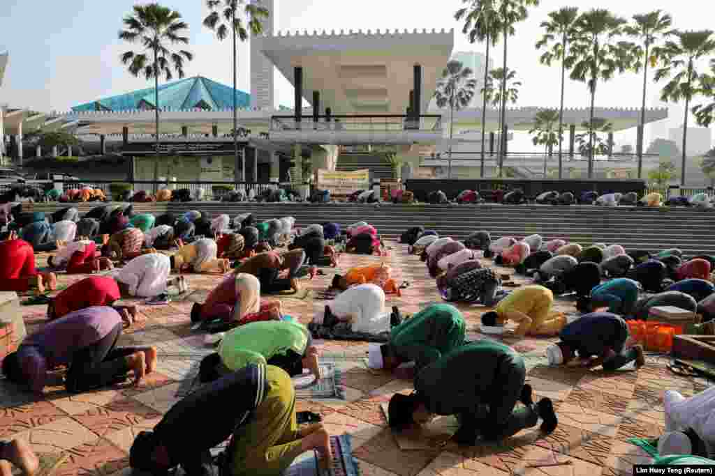 Мусульмане молятся возле закрытой Национальной мечети Негара в Куала-Лумпуре, Малайзия