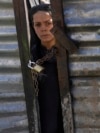 An Afghan boy looks through a locked door as he waits his turn to receive food supplies during a distribution of humanitarian aid for families in need, in Kabul.