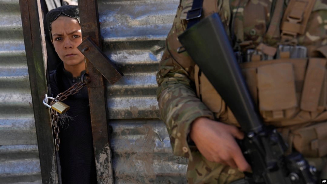 Un băiat afgan își așteaptă rândul să primească provizii de alimente în timpul unei distribuții de ajutor umanitar pentru familiile nevoiașe. Kabul, Afganistan.