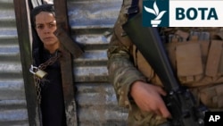 Një djalë afgan shikon përmes një dere të mbyllur ndërsa pret radhën e tij për të marrë ushqim gjatë shpërndarjes së ndihmave humanitare për familjet në nevojë, në Kabul.