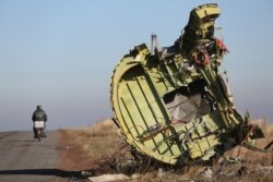 A man rides a motorbike past the wreckage of Malaysian Airlines Flight MH17 in eastern Ukraine in 2014.