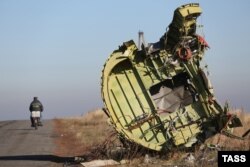 A man rides a motorbike past the wreckage of Malaysian Airlines Flight MH17 in eastern Ukraine in 2014.
