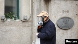 Мужчина в маске на улице в Ухане. 7 февраля 2020 года.