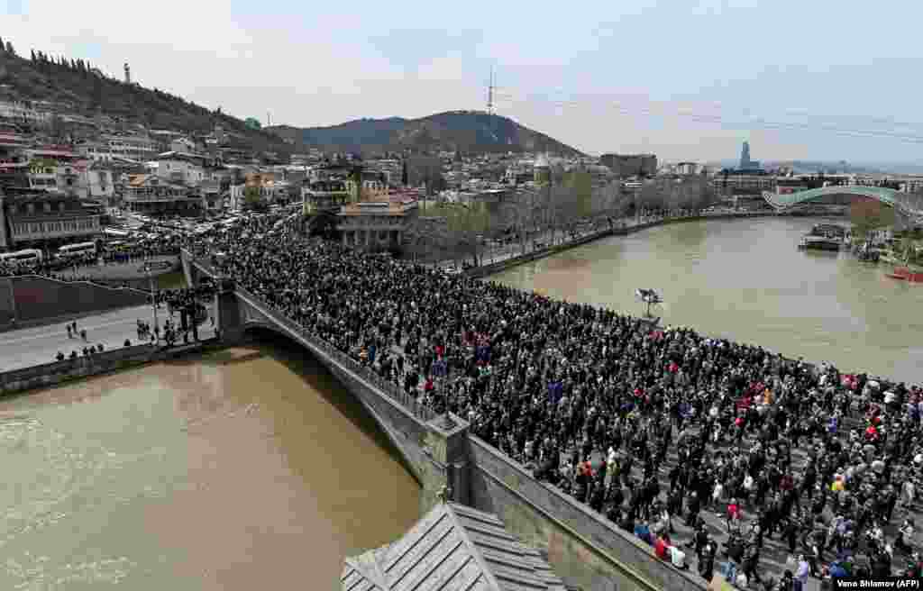 Georgians cross a bridge during a rally in memory of the victims of the violent Soviet crackdown on protesters demanding independence for the Caucasus republic in 1989, in Tbilisi on April 9. (AFP/Vano Shlamov)