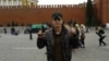 A man identified as Tajik Alan Chekranov holding a pistol and extending one finger -- a common sign used by Islamist militants to mean "one," an attestation of belief in tawhid, or monotheism -- at Red Square in Moscow, possibly in 2012.