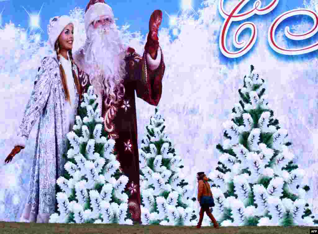 A man walks past a huge holiday Christmas and New Year's poster in Minsk. (AFP/Sergei Gapon)