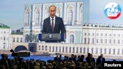 Russia -- Russian President Vladimir Putin is seen on a screen as he speaks during a session of the St. Petersburg International Economic Forum 2015 (SPIEF 2015) in St. Petersburg, Russia, June 19, 2015.