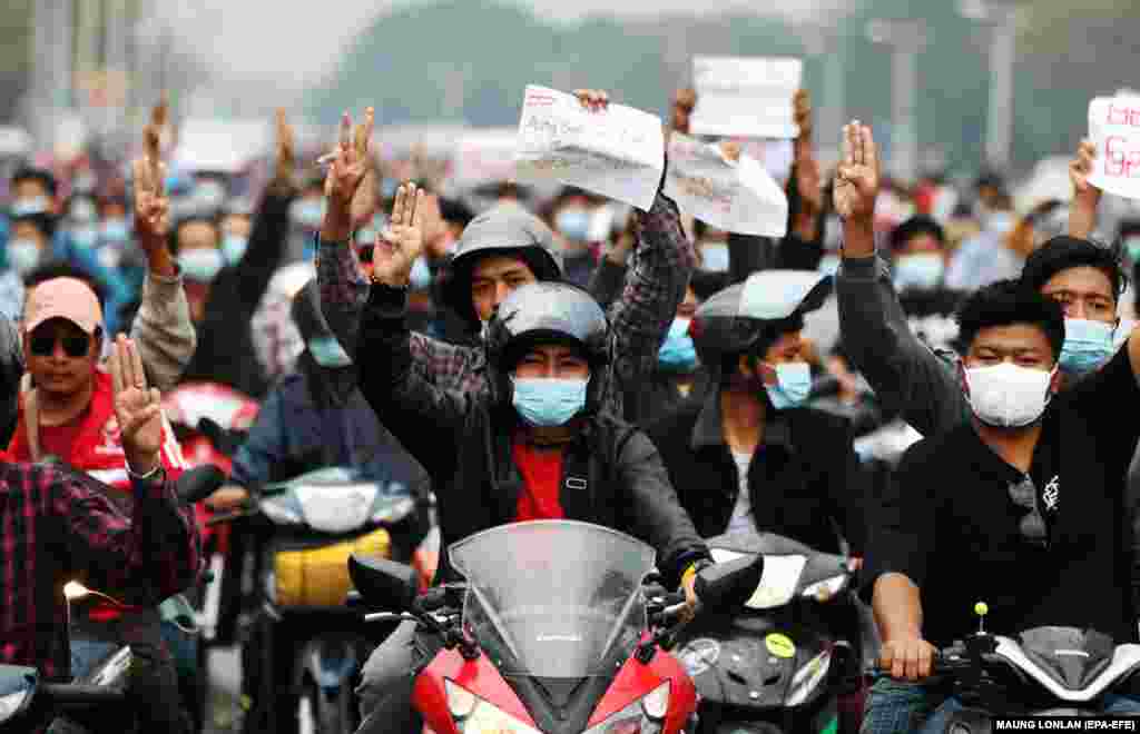 Motocicliștii arată salutul cu trei degete, un simbol al rezistenței, și țin semne pe care scrie &bdquo;Aung San Suu Kyi liber&rdquo; în timpul unui protest împotriva loviturii de stat militare din Naypyitaw, Myanmar, 7 februarie 2021. 