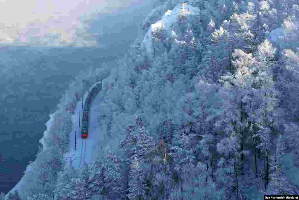 A passenger train moves along the bank of the Yenisei River in the Siberian forest covered with snow and hoarfrost outside Krasnoyarsk, Russia. (Reuters/Ilya Naymushin)