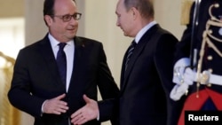 French President Francois Hollande (left) shakes hands with Russian President Vladimir Putin after a summit on the Ukraine crisis at the Elysee Palace in Paris on October 2. 