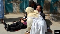 A doctor treats an injured lawyer at the scene of a suicide attack in the southwestern Pakistani city of Quetta. The August 8 attack killed 75 people. Most victims were lawyers.