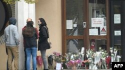Ljudi ostavljaju cvijeće na mjesto ubistva nastavnika Samuela Patija, Conflans-Sainte-Honorine u blizini Pariza