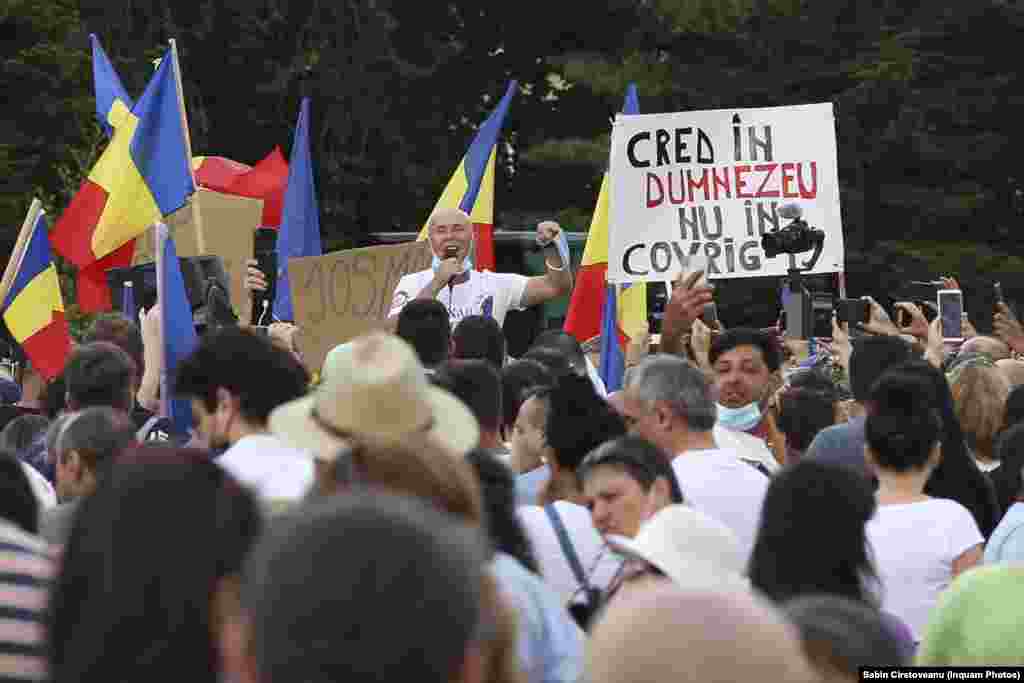 În România - ca peste tot în lume - numărul conspiraționiștilor a început să fie din ce în ce mai mare. Mulți români se îndoiesc și în prezent că restricțiile sunt justificate sau chiar că virusul ar fi real. Mugur Mihăescu, un comediant cu priză la public în anii 2000, este una dintre figurile cunoscute din rândul conspiraționiștilor. El apare în această imagine surprinsă la un protest ce a avut loc la București împotriva măsurilor impuse de autorități.