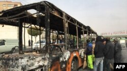 Iranians inspect the wreckage of a bus that was set ablaze by protesters during a demonstration against a rise in gasoline prices in the central city of Isfahan, November 17, 2019