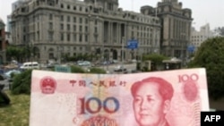 تصویری از اسکناس 100 یوآنی در برابر ساختمان یک بانک در شهر شانگهای