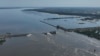 Вода тече через зруйновану греблю Каховської ГЕС в окупованій військовими РФ Новій Каховці, 7 червня 2023 року