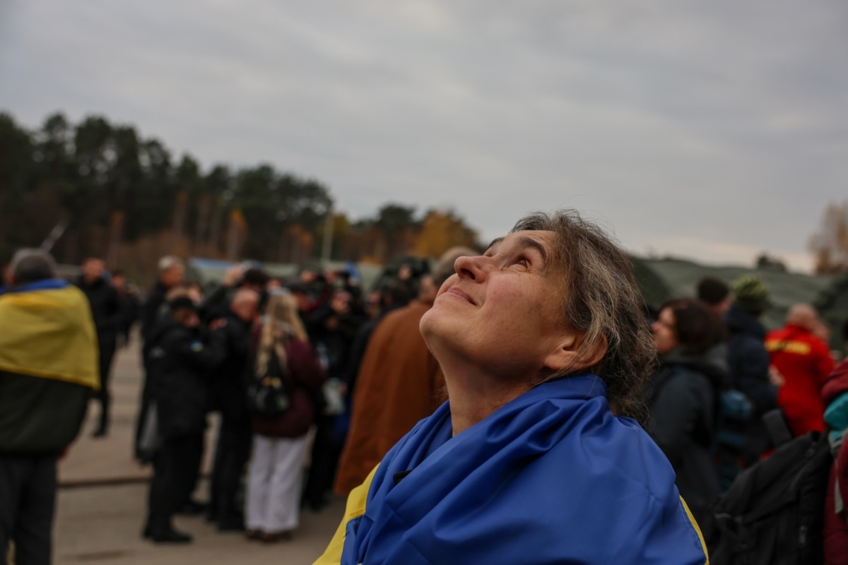Евакуйована з окупованих Олешків жінка дивиться в небо вже на вільній території