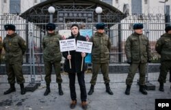 In fața ambasadei ruse din Kiev, un manifestant poartă pancarte cu nume de tătari din Crimeea dispăruți, 25 octombrie 2016
