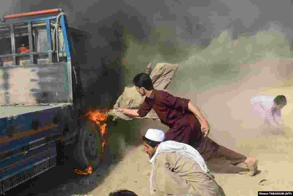 Men try to extinguish a burning truck set on fire by rioters after a bomb blast targeting Shi&#39;ite Muslims in Karachi, Pakistan, on March 4.