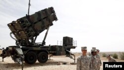 U.S. soldiers stand beside a U.S. Patriot missile system at a Turkish military base in Gaziantep.