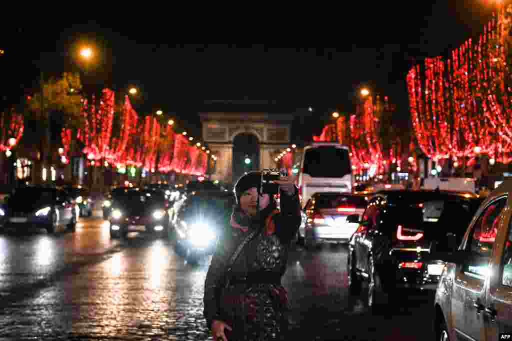 A person takes selfies on Champs Elysees avenue in Paris on November 22 after the Christmas lights were turned on. (AFP/Sergei Supinsky)