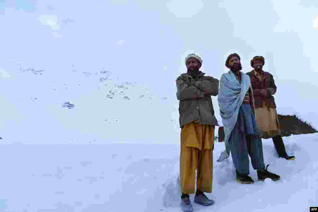 Residents of Bazarak district in Panjshir Province walk down a mountainside after searching for avalanche victims.