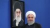 حسن روحانی در کنار عکس رهبر جمهوری اسلامی که چندی پیش بر کنار کشیدن از برجام تاکید کرد