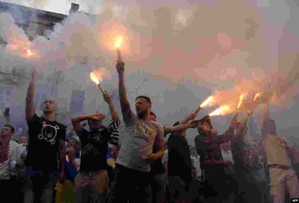 Ukrainian football supporters of FC Dynamo Kyiv, FC Karpaty Lviv, and FC Shakhtar Donetsk hold flares and shout slogans during a &quot;March of Unity&quot; in Lviv. (AFP/Yurko Dyachyshyn)