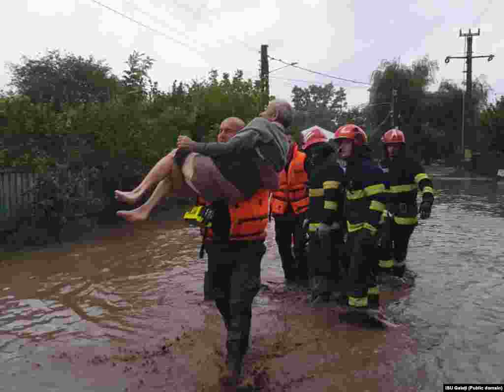 Un bărbat este salvat de pompieri din locuința sa după inundațiile care au afectat județele Galați și Vaslui.&nbsp;