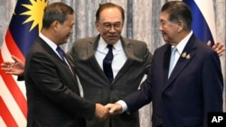 Kambodžanski premijer Hun Manet (lijevo) i vršilac dužnosti premijera Tajlanda Phumtham Wechayachai (desno) rukuju se pored malezijskog premijera Anwara Ibrahima nakon razgovora o prekidu vatre između Tajlanda i Kambodže u Putrajayi, Malezija, 28. jula 2025.