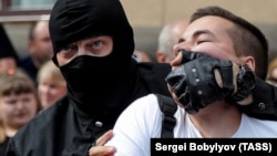 Thousands of people have been detained and many of them have been beaten by Lukashenka's security forces, their faces often obscured by masks, balaclavas, or riot helmets. Here, a riot police officer detains an opposition supporter in Minsk on August 30.