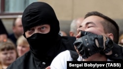Pripadnik beloruske specijalne policije privodi pristalicu opozicije na protestu u Minsku 30. avgusta.