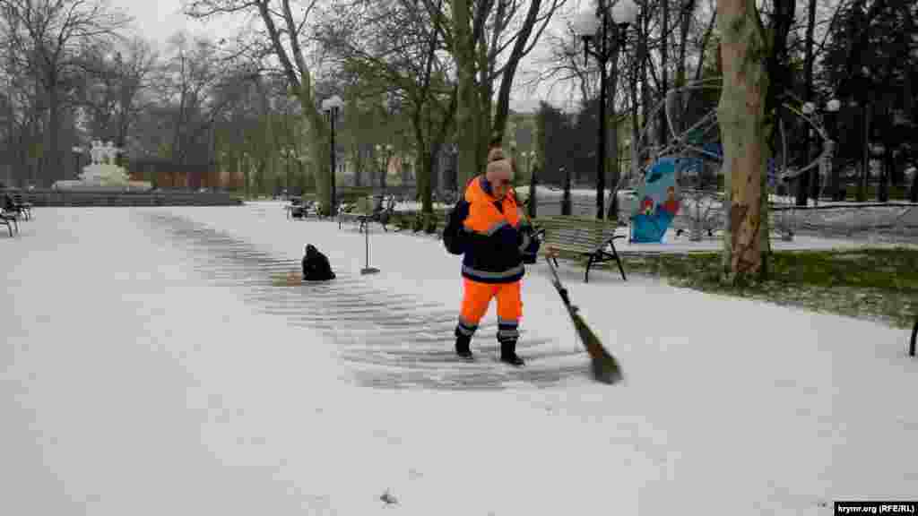 Работник коммунальной службы расчищает дорогу в Севастополе