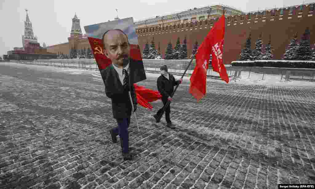 Ruski komunisti nose portret Vladimira Lenjina i mašu crvenim zastavama u znak obilježavanja 97. godišnjice smrti sovjetskog lidera u blizini njegovog mauzoleja na Crvenom trgu u Moskvi, 21. januara. (Epa-EFE / Sergej Ilnitski)