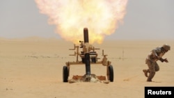 A Saudi soldier fires a mortar toward Huthi positions at the Saudi border with Yemen on April 21.