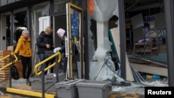 Apotekarke provjeravaju lijekove u oštećenoj apoteci u blizini stanice metroa, koja je pogođena tokom ruskog raketnog napada na Kijev u noći 19. oktobra.