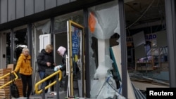 19-njy oktýabr gijesi Kiýewe edilen rus raketa hüjümi wagtynda, metro stansiýasynyň golaýyndaky zeper ýeten dermanhanada işgärler dermanlary gözden geçirýärler.